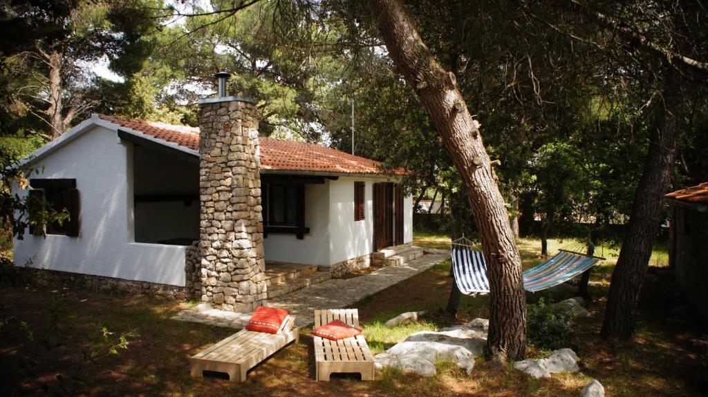 mały dom z ceglanym kominem i ławką w obiekcie Holiday Home Pine Villa w Pakoštane