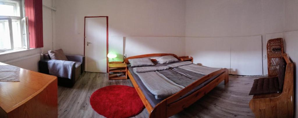 1 dormitorio con cama y alfombra roja en Szelíd Tisza Vályog Vendégház Tiszafüred en Tiszafüred