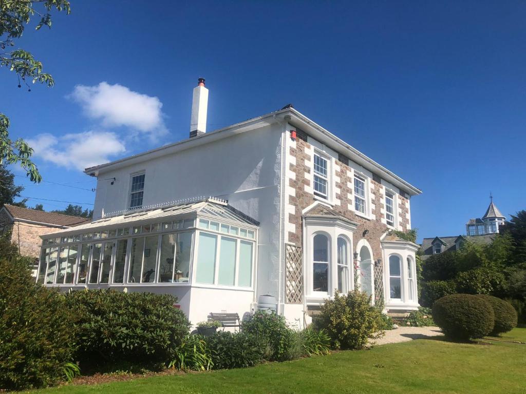 Ivy House Cornwall B&B في سانت أوستيل: منزل أبيض كبير مع نافذة كبيرة