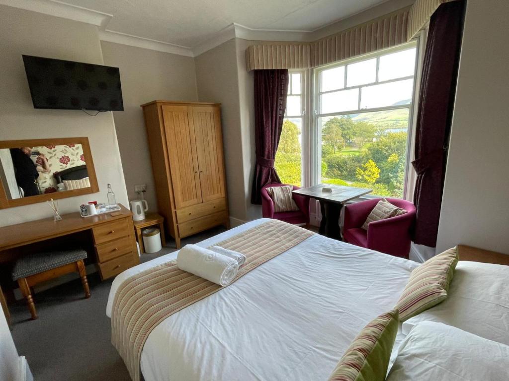um quarto de hotel com uma cama, uma secretária e uma janela em Ouse Bridge House em Bassenthwaite Lake