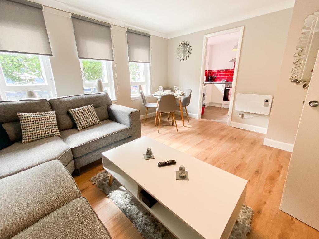 a living room with a couch and a table at Glasgow 2bd City Centre Apartment - Free Private Parking in Glasgow