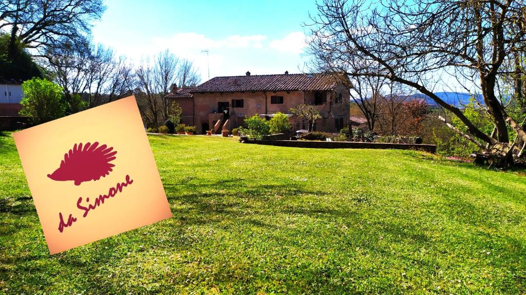 un panneau dans une cour devant une maison dans l'établissement Da Simone podere santi Lucia e Pietro, à Sienne