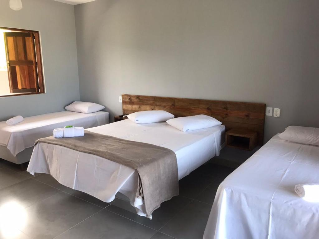 a bedroom with two beds with white sheets at Recanto Filadélfia in Paraty