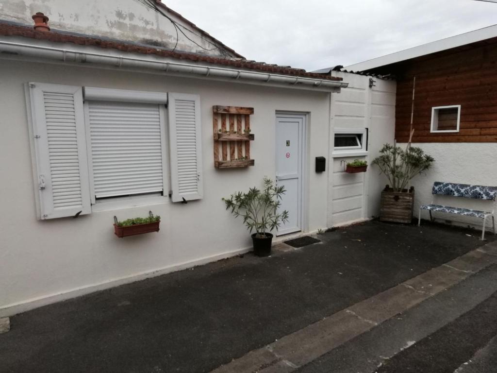 une maison blanche avec des portes et des plantes blanches dans l'établissement SAMANKE lOUNGE, à Floirac