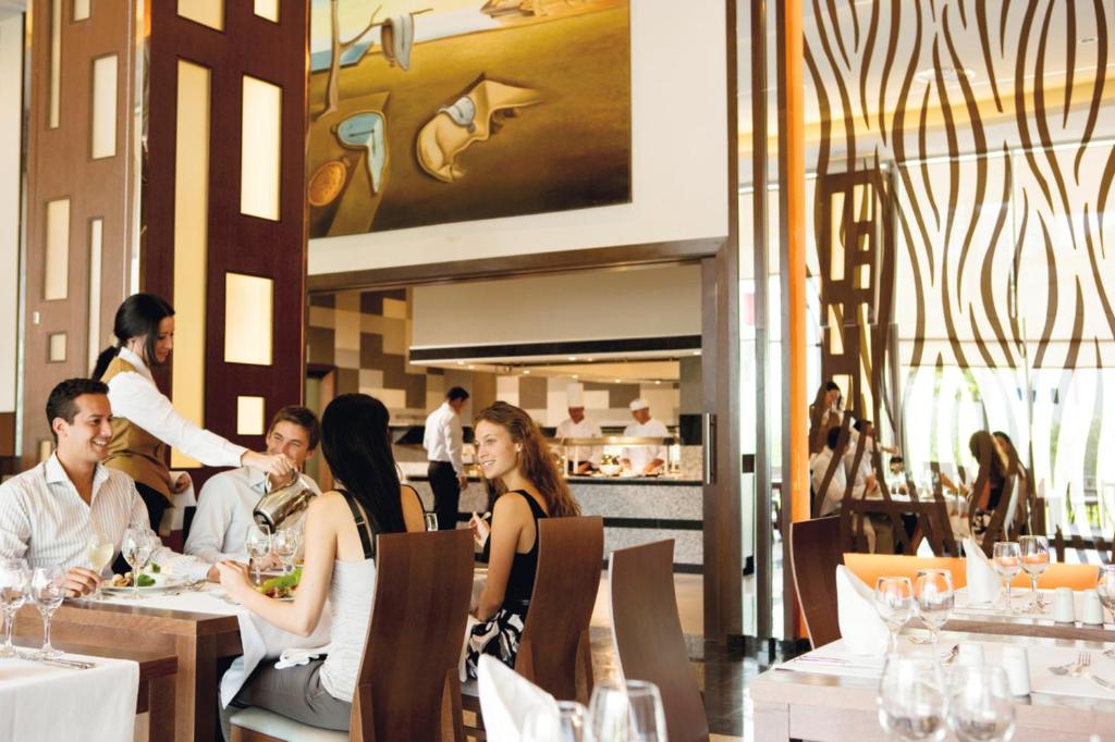 a group of people sitting at tables in a restaurant at Riu Plaza Panamá in Panama City