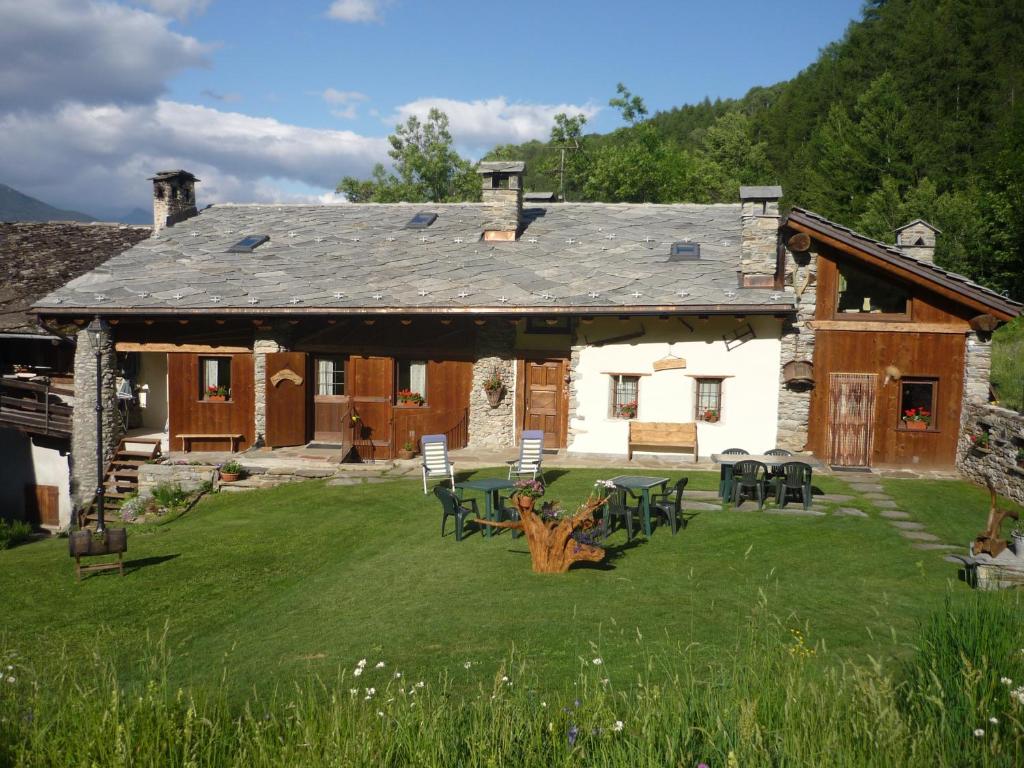 een huis met tafels en stoelen in de tuin bij Les Chevreuils in Arvier