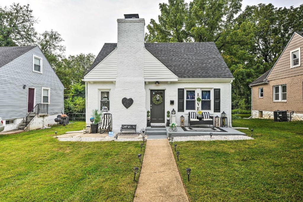 a white house with a porch and a yard at Chic Baltimore Retreat - 6 Mi to Downtown! in Baltimore