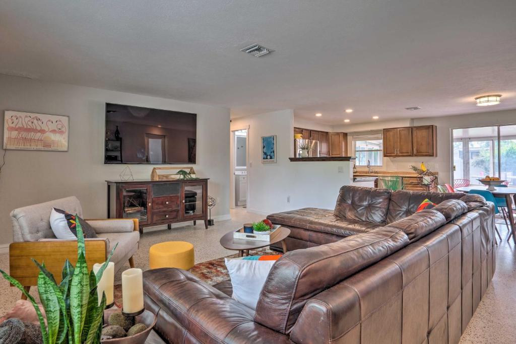 uma sala de estar com um sofá de couro castanho em Colorful Fort Myers Home with Sunroom and Patio! em Fort Myers