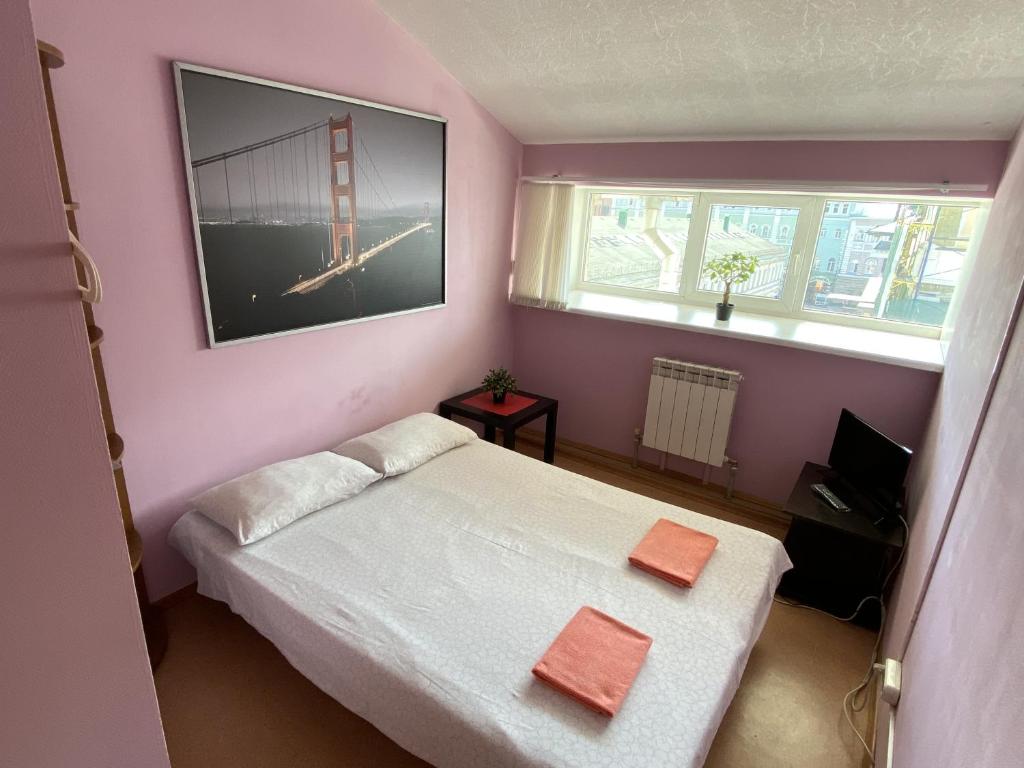 ニジニ・ノヴゴロドにあるGuest House Litvichの小さなベッドルーム(ベッド1台、窓付)