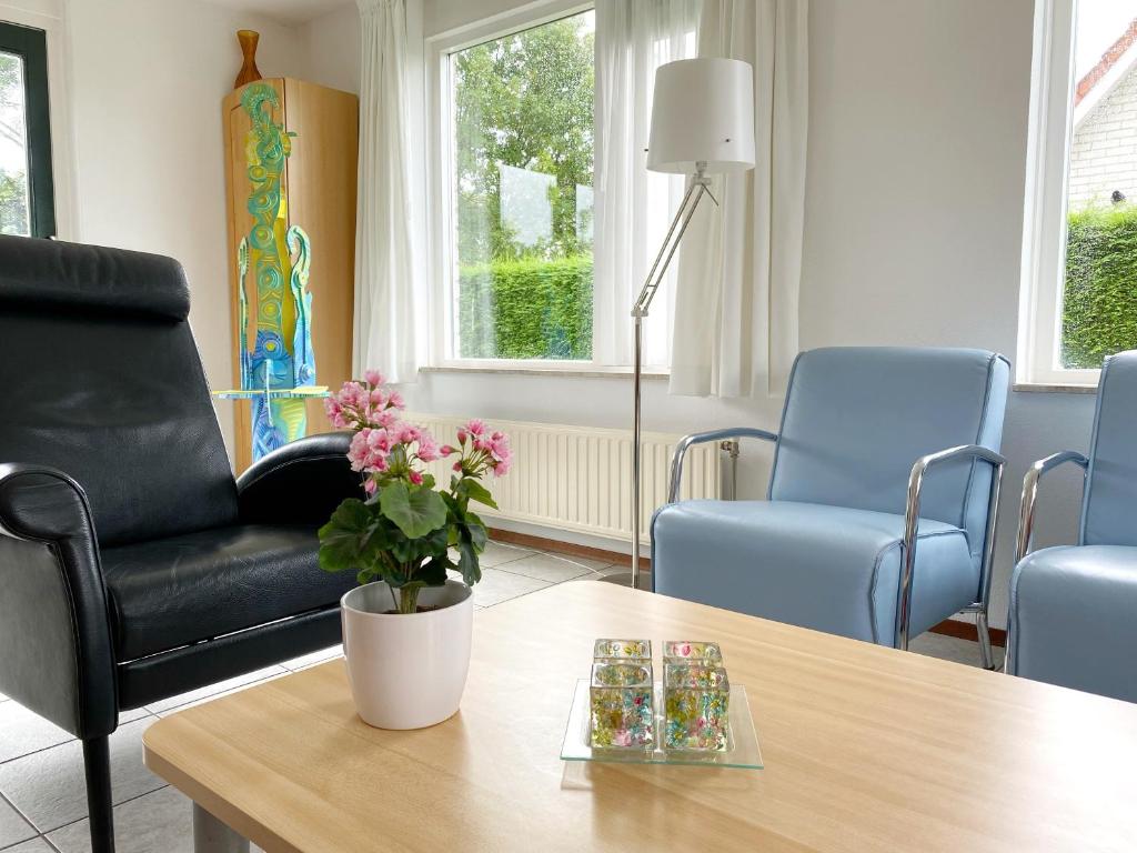 a living room with a black chair and a table at Hello Zeeland - Vakantiehuis Stern 263 in Breskens