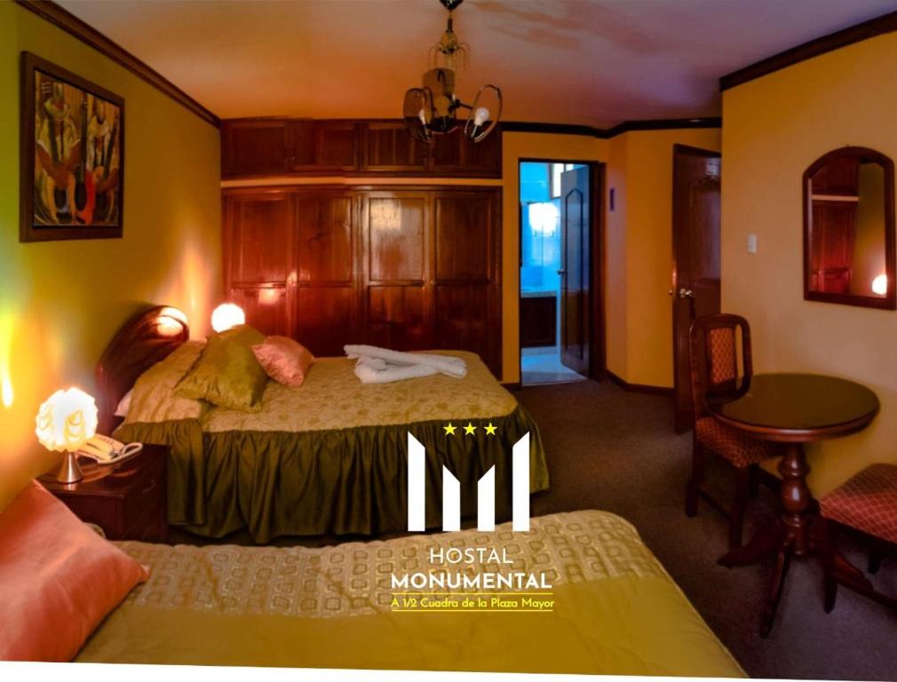 a bedroom with a bed and a table in a room at HOSTAL MONUMENTAL a Media Cuadra de la Plaza Mayor in Cajamarca