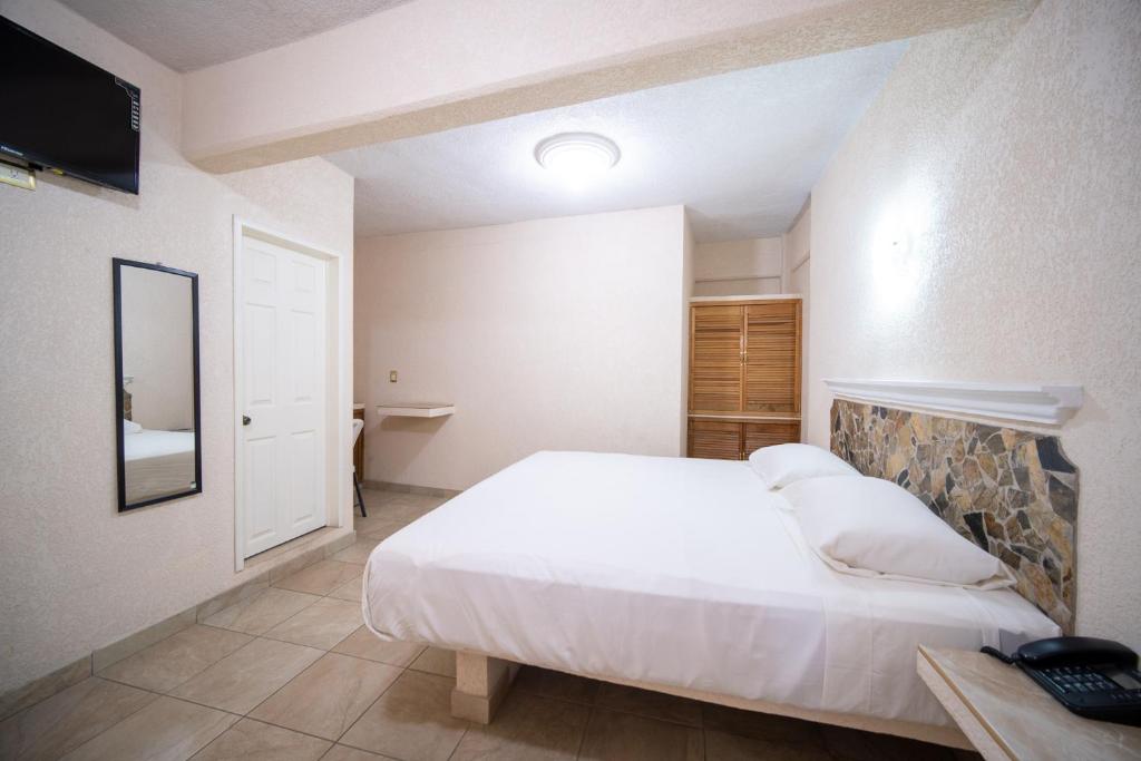 a bedroom with a large white bed in a room at PENINSULA STAYS Executive Hotel in Salina Cruz