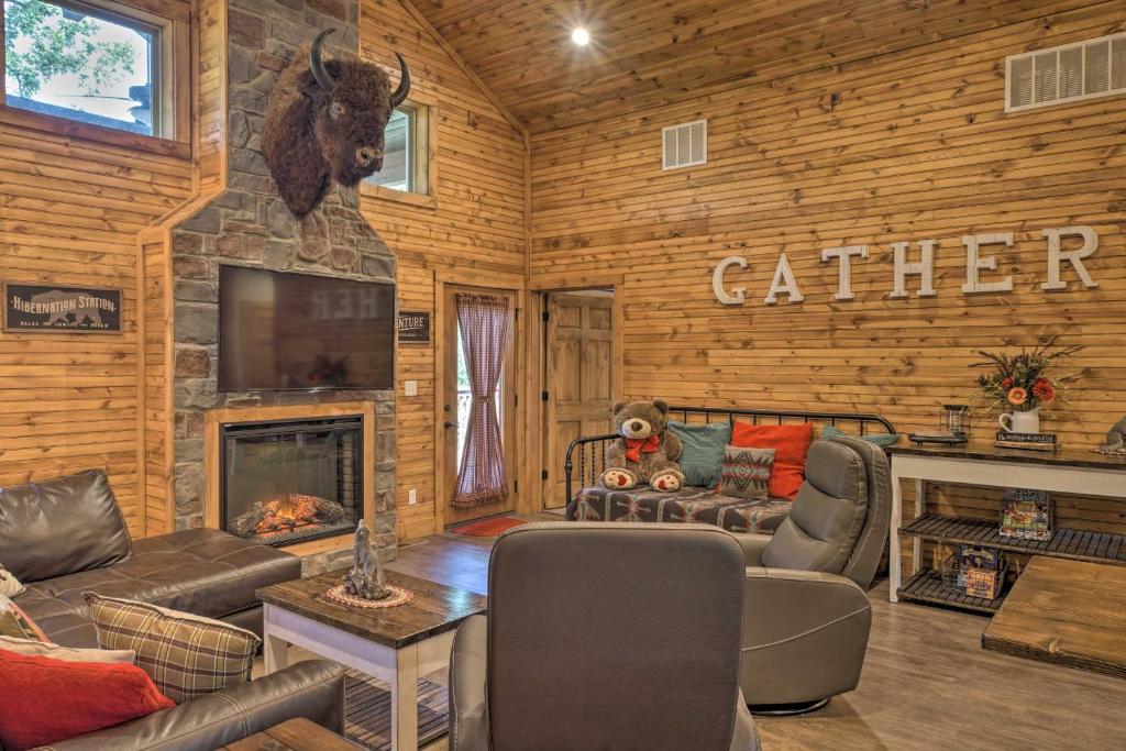 - un salon en rondins avec une cheminée en pierre dans l'établissement Relax Fireside Family-Friendly Branson West Cabin, à Branson West