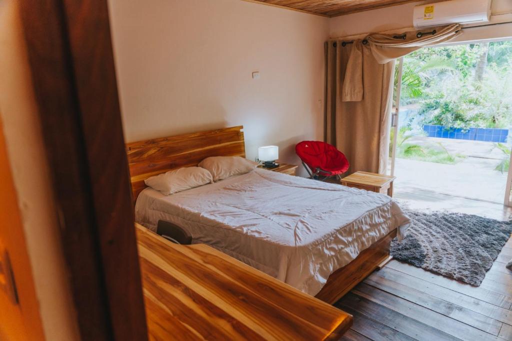 a bedroom with a bed and a large window at Hostal Hilltop Palomino in Palomino