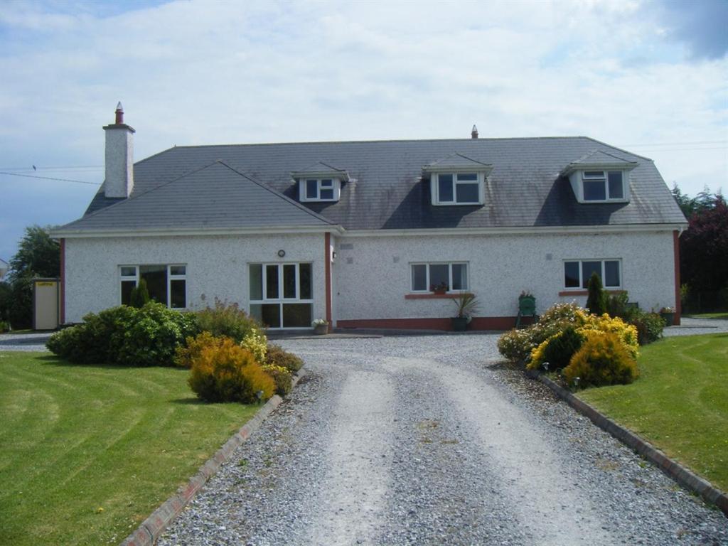 a large white house with a gravel driveway at Dun Cromain B&B in Banagher