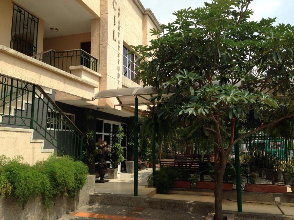 ein Gebäude mit einem Baum vor einem Gebäude in der Unterkunft Cecil Aparta Estudios in Barranquilla