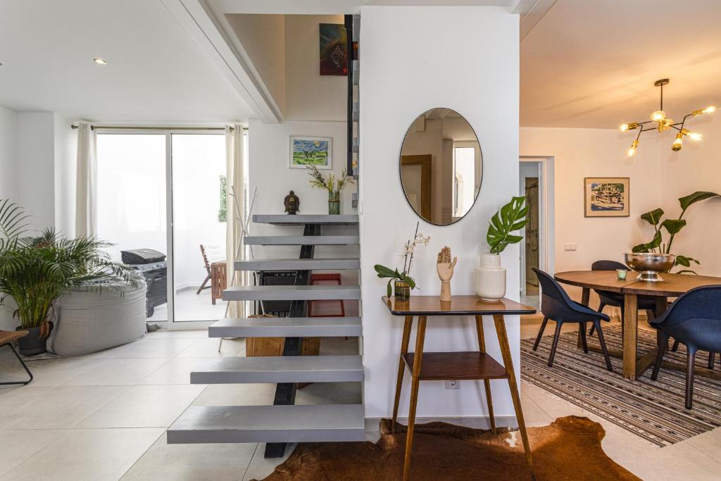 een trap in een woonkamer met een tafel en stoelen bij Casa Lobo - 2 bedrooms - Duplex in Faro