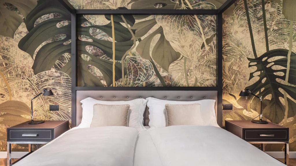 1 dormitorio con 1 cama grande y una pintura en la pared en Palm Loggias Meran, en Merano