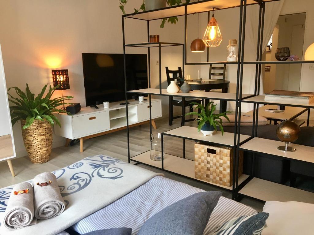 uma sala de estar com um sofá e uma televisão em 'Das kleine Feine' - Ruhige, helle Ferienwohnung mit Parkplatz und Balkon em Pforzheim