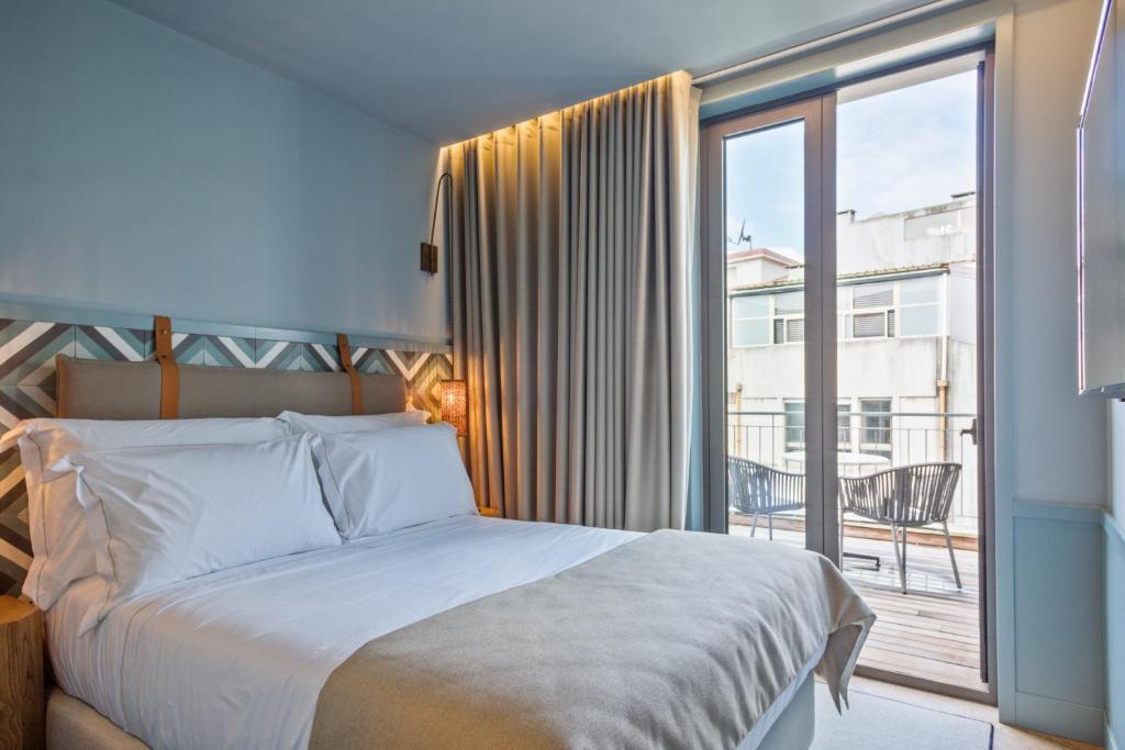 een slaapkamer met een bed en een groot raam bij Pur Oporto Boutique Hotel by actahotels in Porto