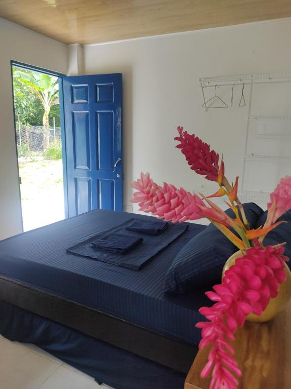 a bedroom with a bed and a blue door at Hotel Puerta Azúl Capurganá in Capurganá