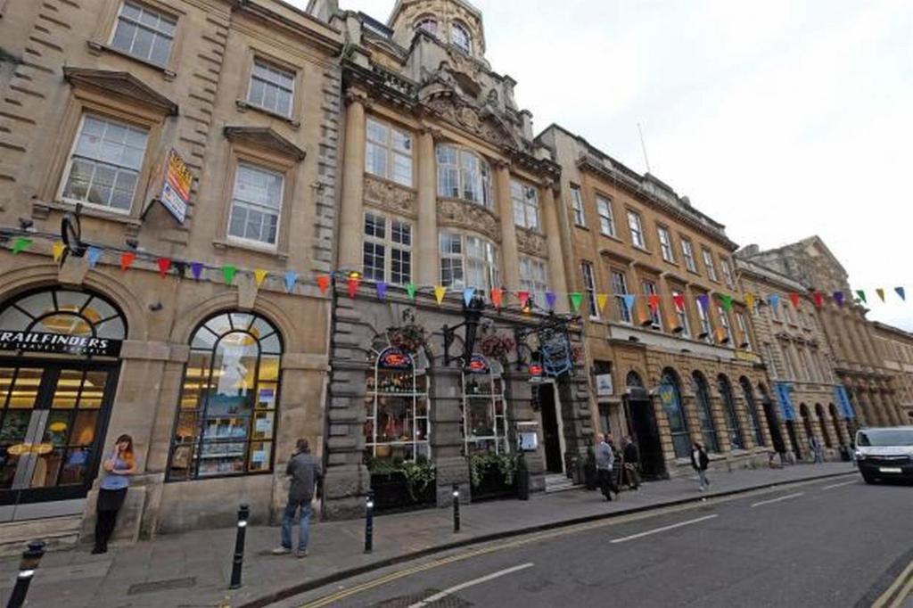 a building on a street with people walking in front of it at Historic two bed apartment in Heart of the City in Bristol