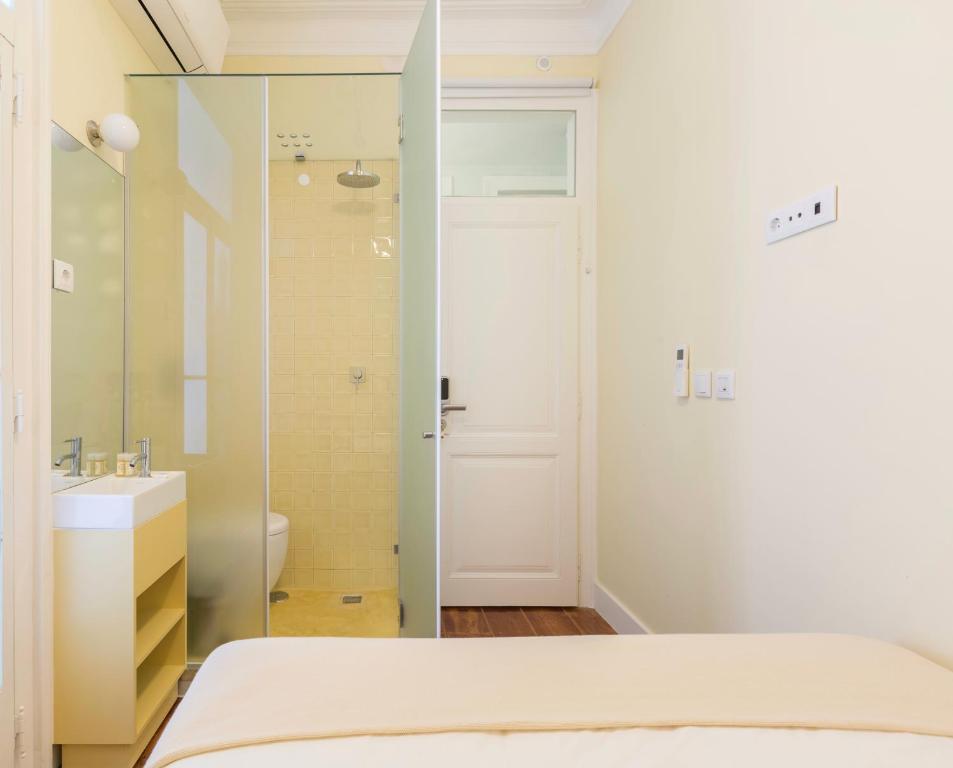 Un dormitorio con una cama, un lavabo y un espejo. en 1898 Home & Suites, en Lisboa