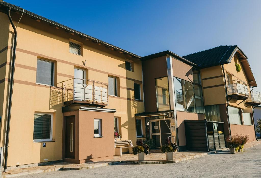 ein Apartmenthaus mit Balkon auf einer Straße in der Unterkunft Furman Apartments Slovenja vas in Spodnja Hajdina