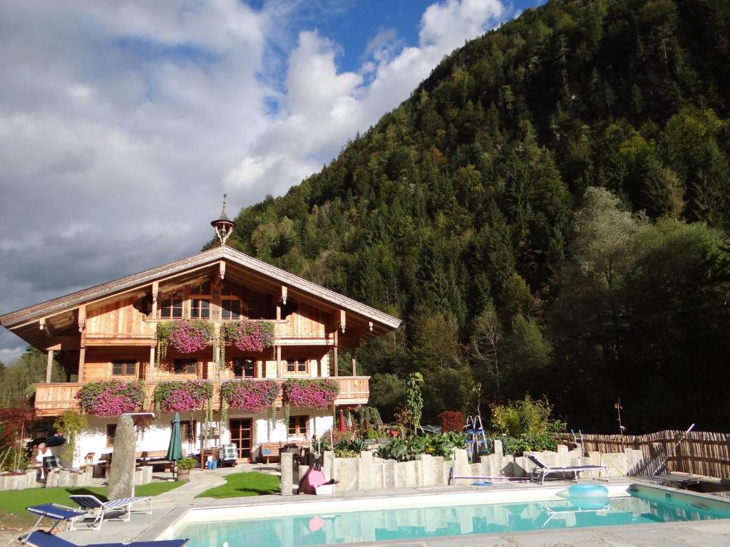 a building with a pool in front of a mountain at Ferienwohnungen Anni im Paradies in Kiefersfelden