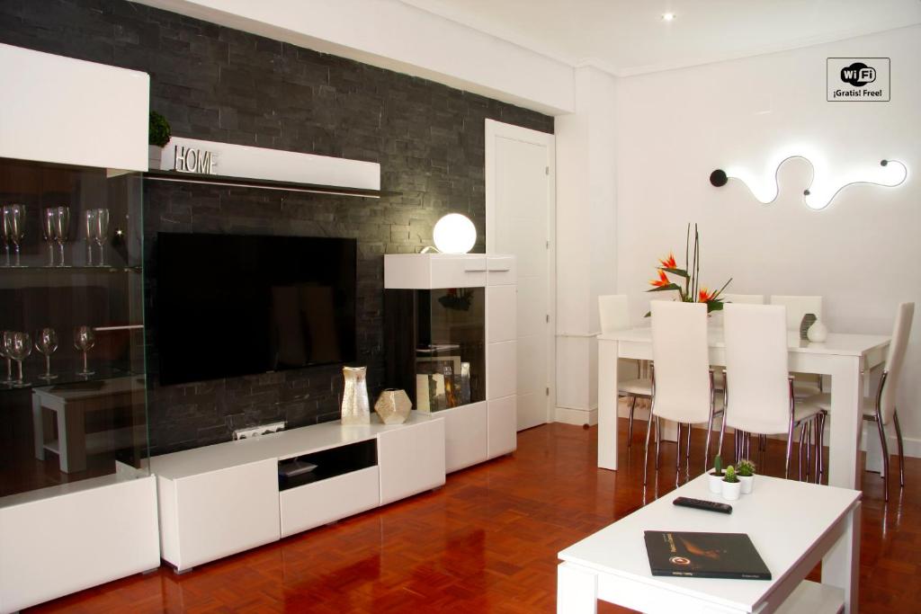 Una sala de estar con un televisor y una mesa y sillas. en Princesa VUT, en Cuenca