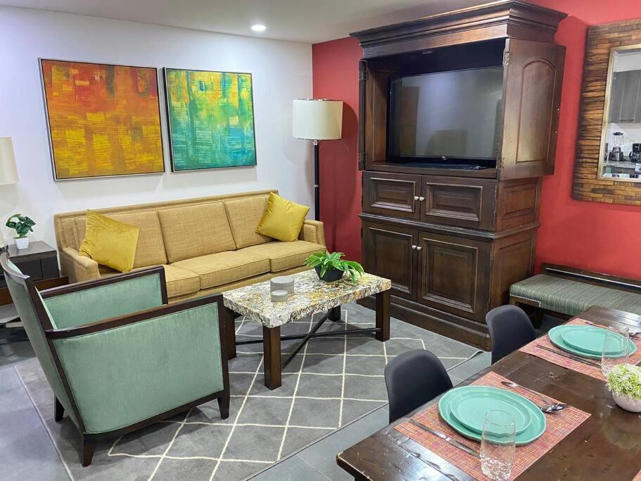 a living room with a couch and a tv at Gran Ubicacion Cerca de SANTAFE, KINGSIZE BED in Mexico City