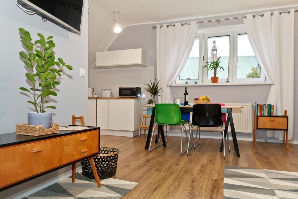 a kitchen and living room with a table and chairs at Old Town Apartments in Szczecin