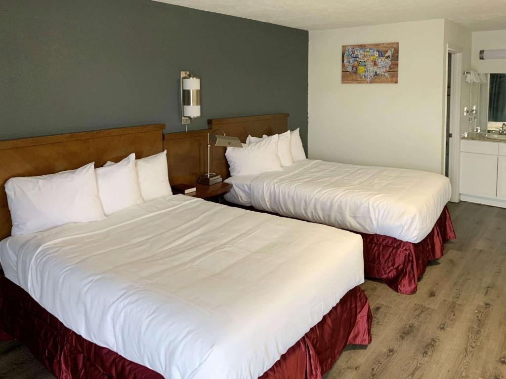- 2 lits dans une chambre d'hôtel avec des draps blancs dans l'établissement Rodeway Inn, à Augusta