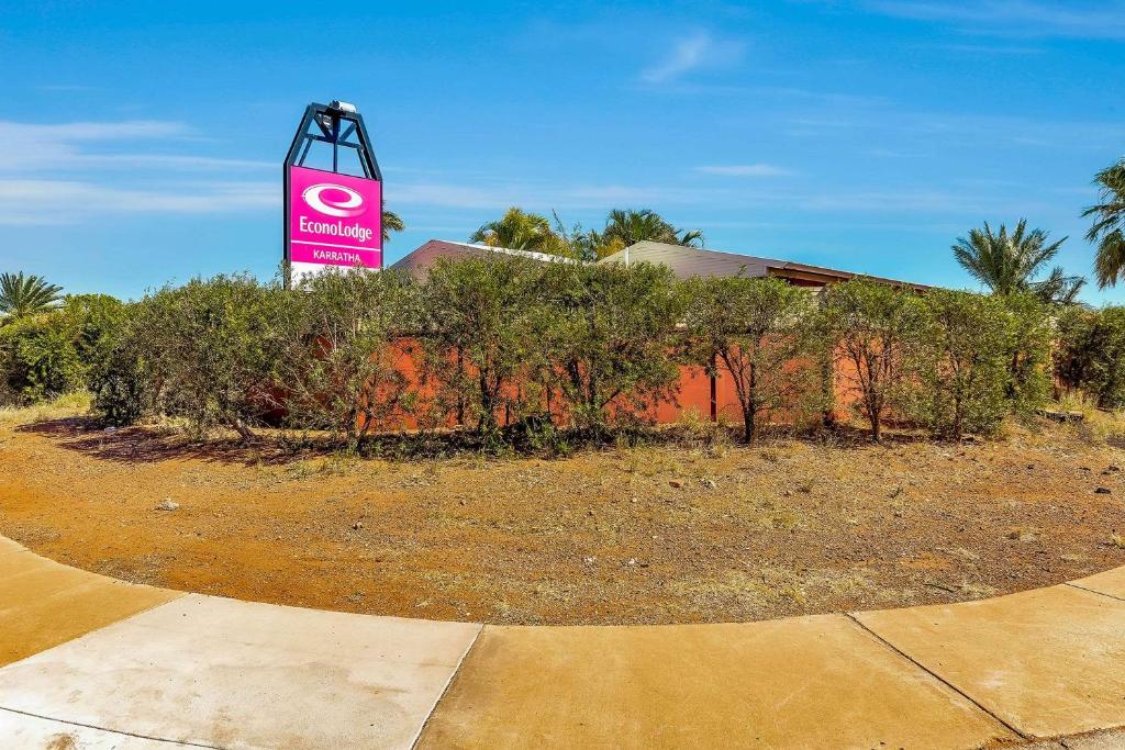 a pink sign in front of a building at Econo Lodge Karratha in Karratha