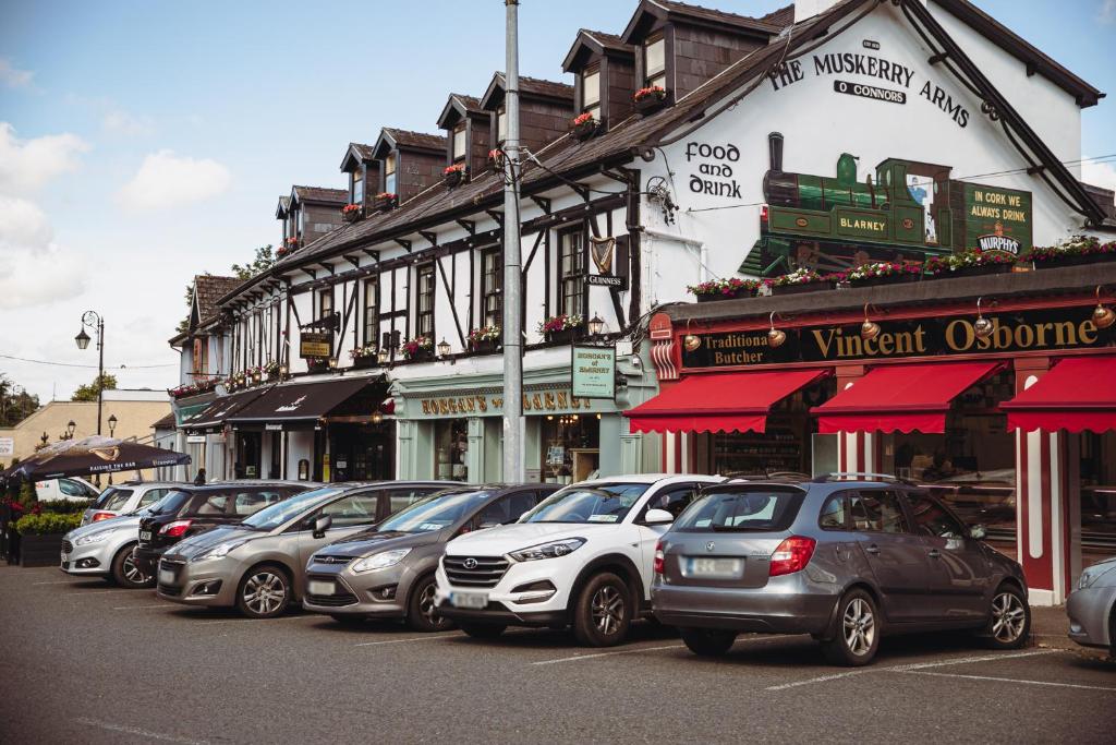
a street scene with cars parked in front of a building at Muskerry Arms Bar and B&B in Blarney
