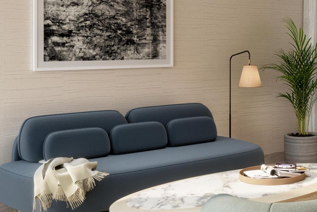 a blue couch in a living room with a table at The Shoals Suites & Slips in Southold