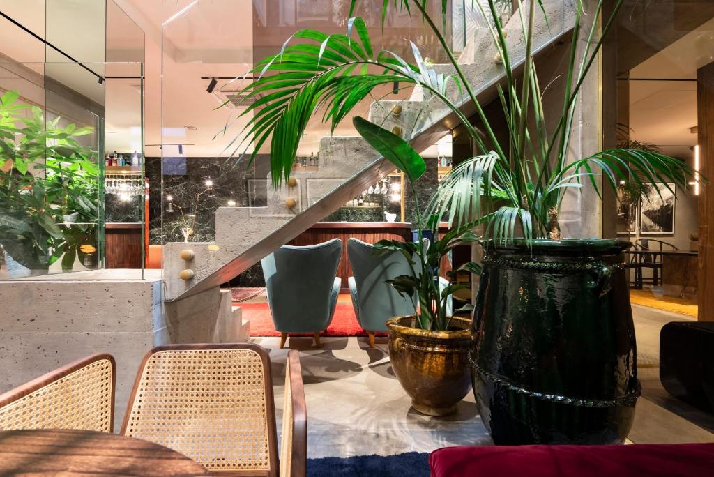 a table with chairs and plants in a room at Vico Milano in Milan