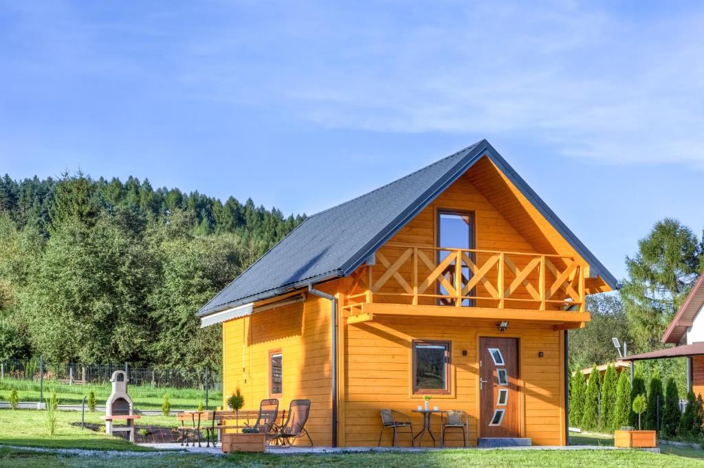 a log cabin with a black roof at Domek całoroczny in Tylicz