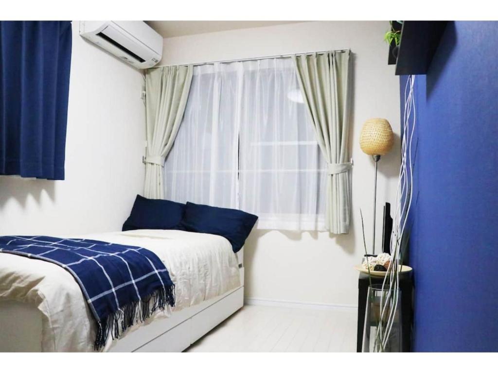a bedroom with a bed and a window at OHANA TOKYO HOUSE - Vacation STAY 73657v in Tokyo