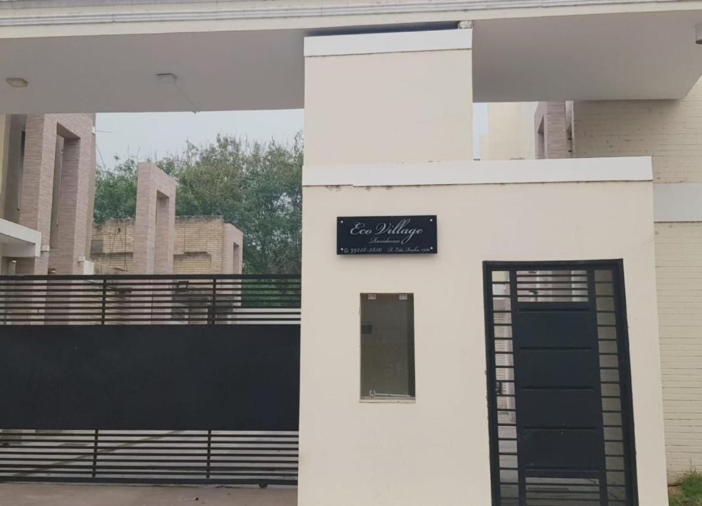 um edifício com uma porta preta e um sinal nele em Sobrado 2 amplo e confortável em condomínio em Corumbá