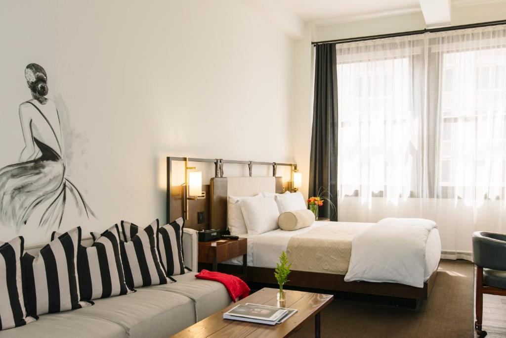 a hotel room with a bed and a couch at Refinery Hotel - New York in New York