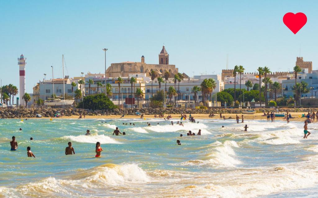 eine Gruppe von Menschen im Wasser an einem Strand in der Unterkunft APARTAMENTO VILLA DE ROTA - VISTA MAR, 135m2, Terraza, SAT TV y más in Rota