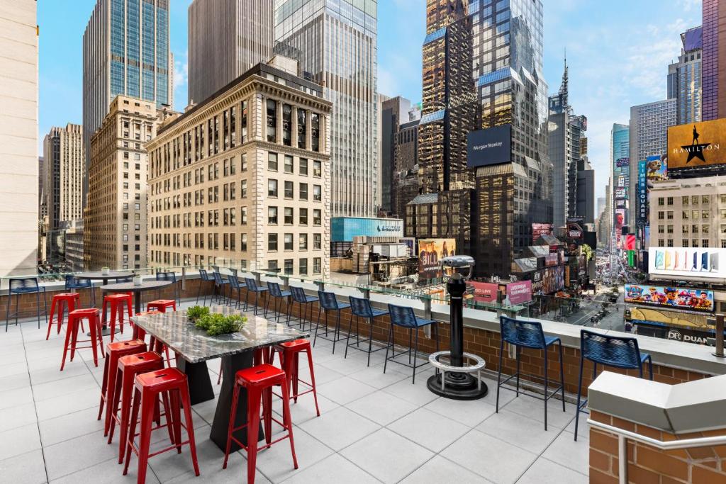 a table and chairs on a rooftop with a view of a city at M Social Hotel Times Square New York in New York