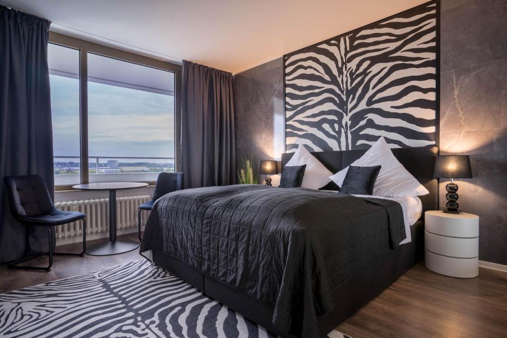 ein Hotelzimmer mit einem Bett und einem großen Fenster in der Unterkunft RüSuite II - Gemütliches Apartment in Rüttenscheid in Essen