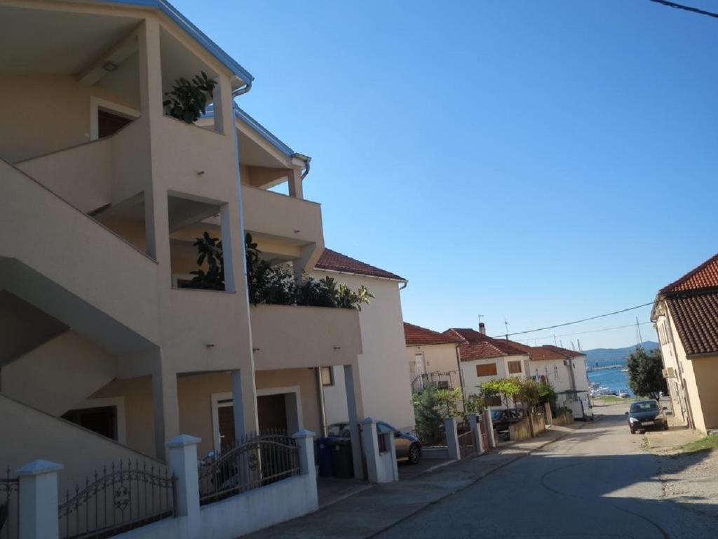 een gebouw met balkons en planten aan de zijkant bij Apartments Ena - near marina Kornati in Biograd na Moru