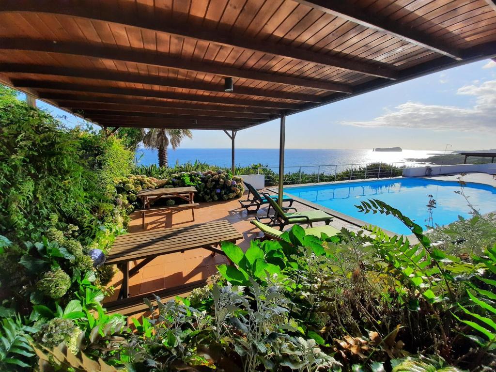 an outdoor patio with a view of the ocean at QVA - Quinta Velha das Amoreiras in Vila Franca do Campo