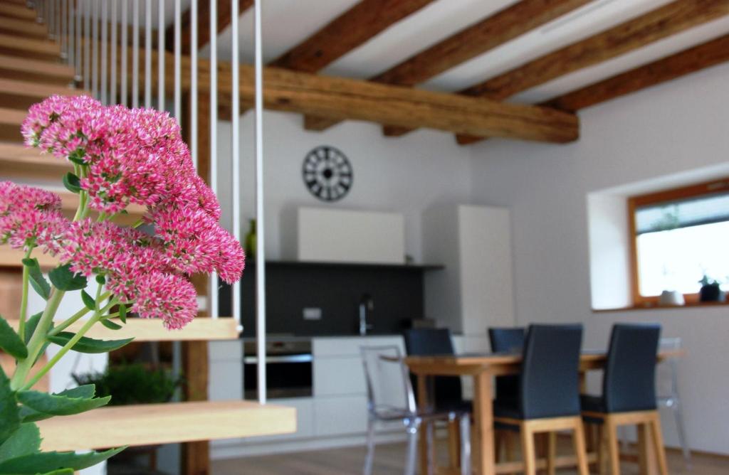 a room with a table and chairs and a clock at Chalet Ur-Gmiatli in Grafendorf bei Hartberg