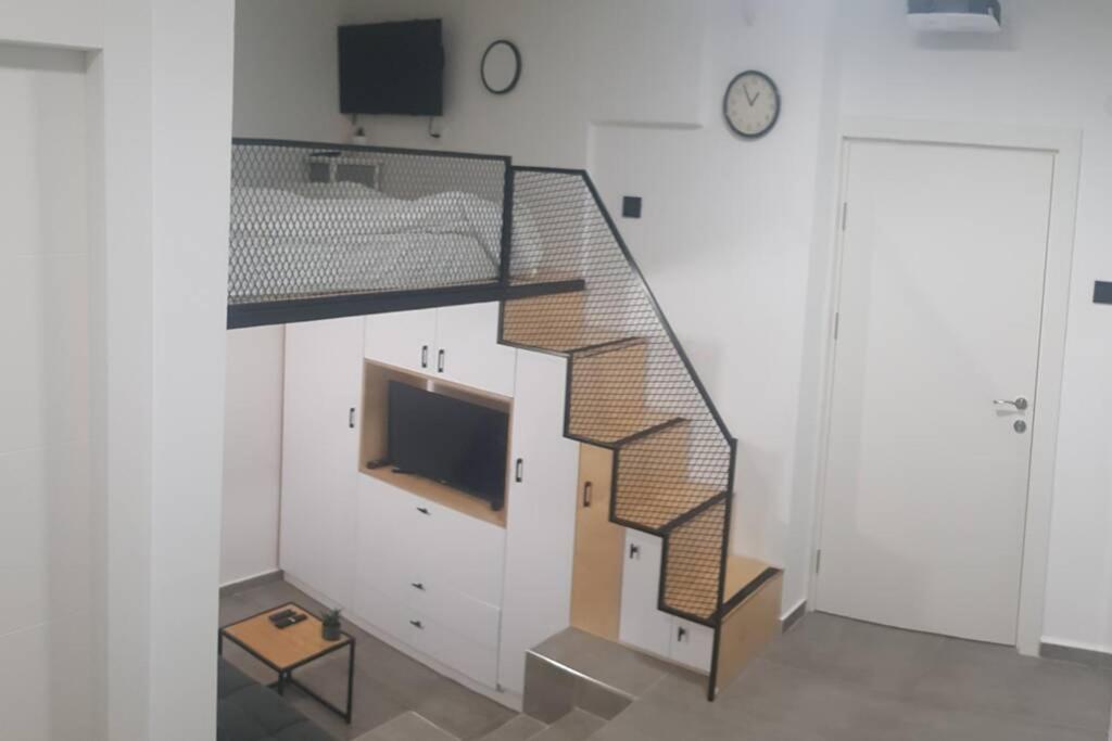 a staircase in a room with a television and a stair case at Centrally-located Quiet Cozy Loft apartment in Beer Sheva
