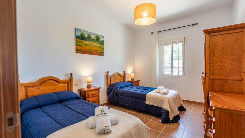 sypialnia z dwoma łóżkami i oknem w obiekcie Casa El Olimpo Alora by Ruralidays w mieście Alora