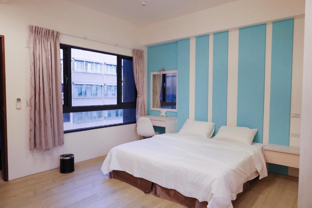a bedroom with a white bed and a window at 71 Cafe B&B in Kaohsiung